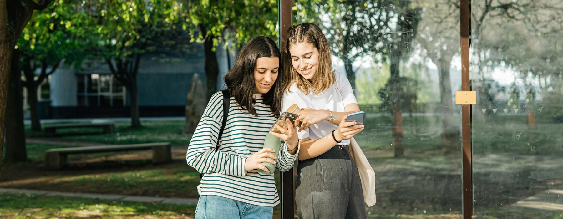 two woman looking at a phone